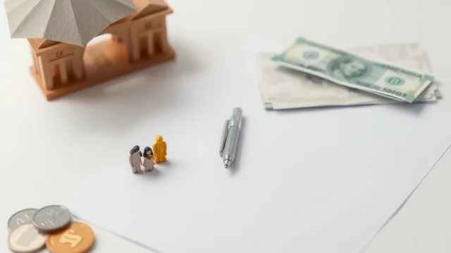 Pen on a blank form beside family figurines and an umbrella, representing life insurance disclosure
