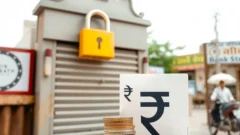 Closed bank shutter with padlock and coins, representing RBI restrictions on a co-operative bank