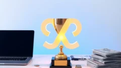 Trophy beside a laptop with abstract digital shapes, representing a regulator technology hackathon win
